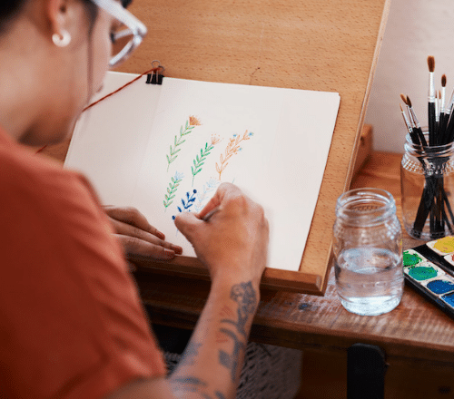 A lady focusing on painting flowers in watercolour.